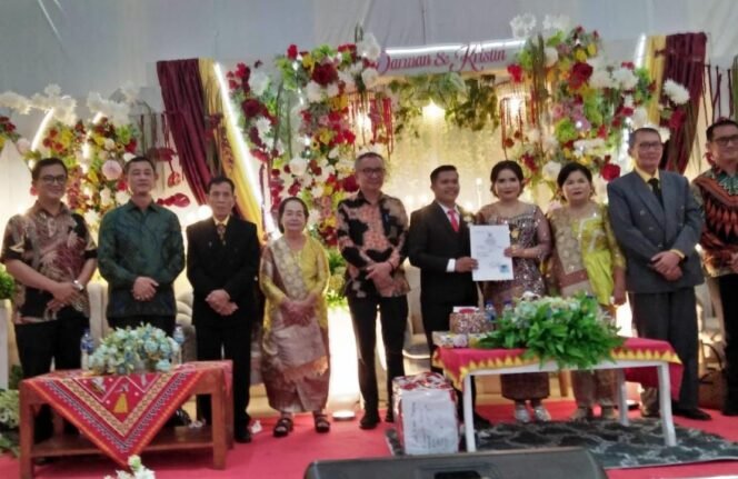 
 Kadis Dukcapil Kab. Nias Hadiri Acara Pesta Adat Dan Menyerahkan Langsung Akta Perkawinan Kepada Kedua Mempelai